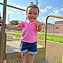 Ella joined the competition — help win amazing prizes! toddler, child, playground, outdoor, smiling, pink_shirt, denim_shorts, crocs, sunny_day, blue_sky, clouds, play_equipment, grass, fence, casual_clothing, happy, cute, person, young_child, summer