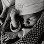 newborn, baby, sleeping, hat, hand, knitted_blanket, black_and_white, close_up, soft_light, peaceful, infant, wrapped, cozy, portrait, cute, tiny_hands, warm, resting, child, face