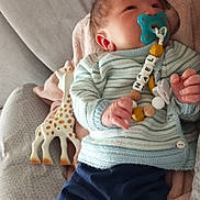Naël a rejoint le concours — aidez-le/la à gagner de superbes lots ! baby, infant, pacifier, toy, giraffe_toy, blanket, clothing, sweater, pants, hand, face, lying_down, bed, soft_toy, cute, child, newborn, comfort, indoor, resting