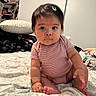 baby, bed, blanket, casual, child, curious, cute, expression, face, furniture, hair_clip, indoors, infant, person, pillow, room, sitting, skin, soft_lighting, striped_clothing