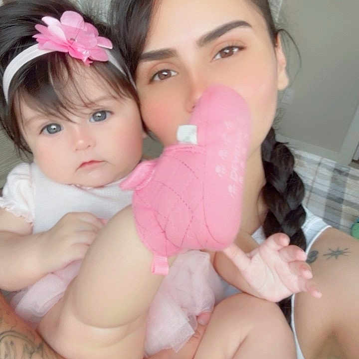 Emily joined the competition — help win amazing prizes! baby, child, adult, portrait, smiling, pink, headband, flower, plush_toy, stuffed_animal, holding, cuddle, indoors, bedroom, door, tattoo, braid, closeup, family, photography