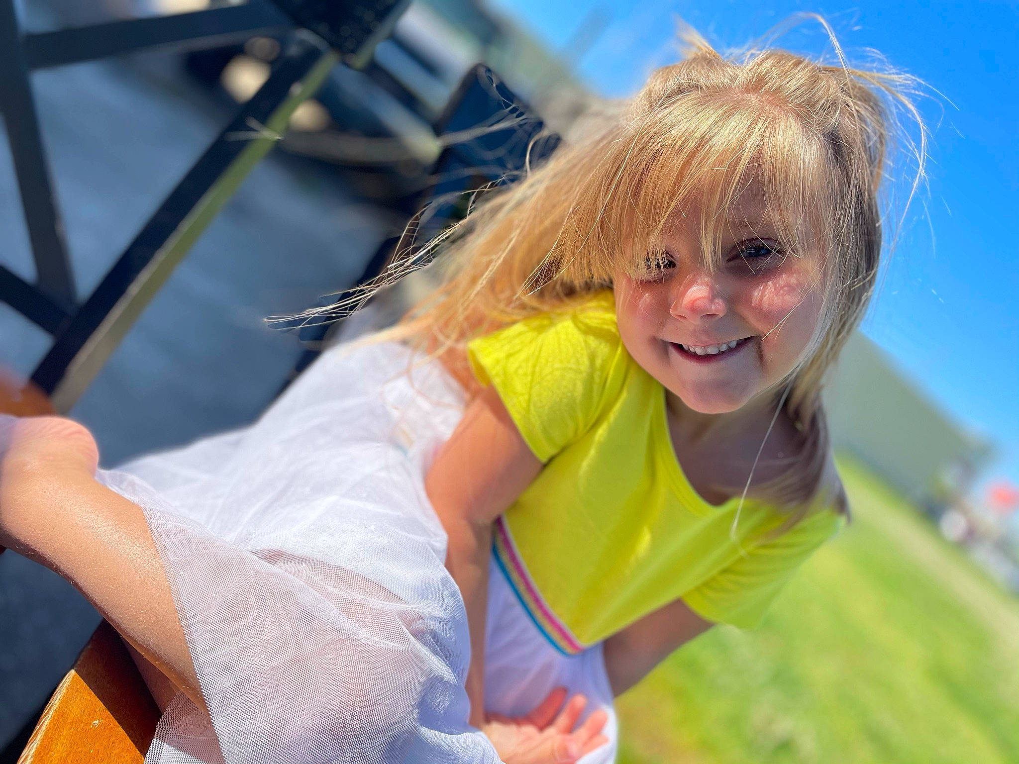 Bailey joined the competition — help win amazing prizes! blond, child, event, fun, grass, grassland, happy, joy, laugh, leisure, outdoor_play_equipment, people_in_nature, person, recreation, sitting, sky, smile, surfer_hair, swing, t_shirt