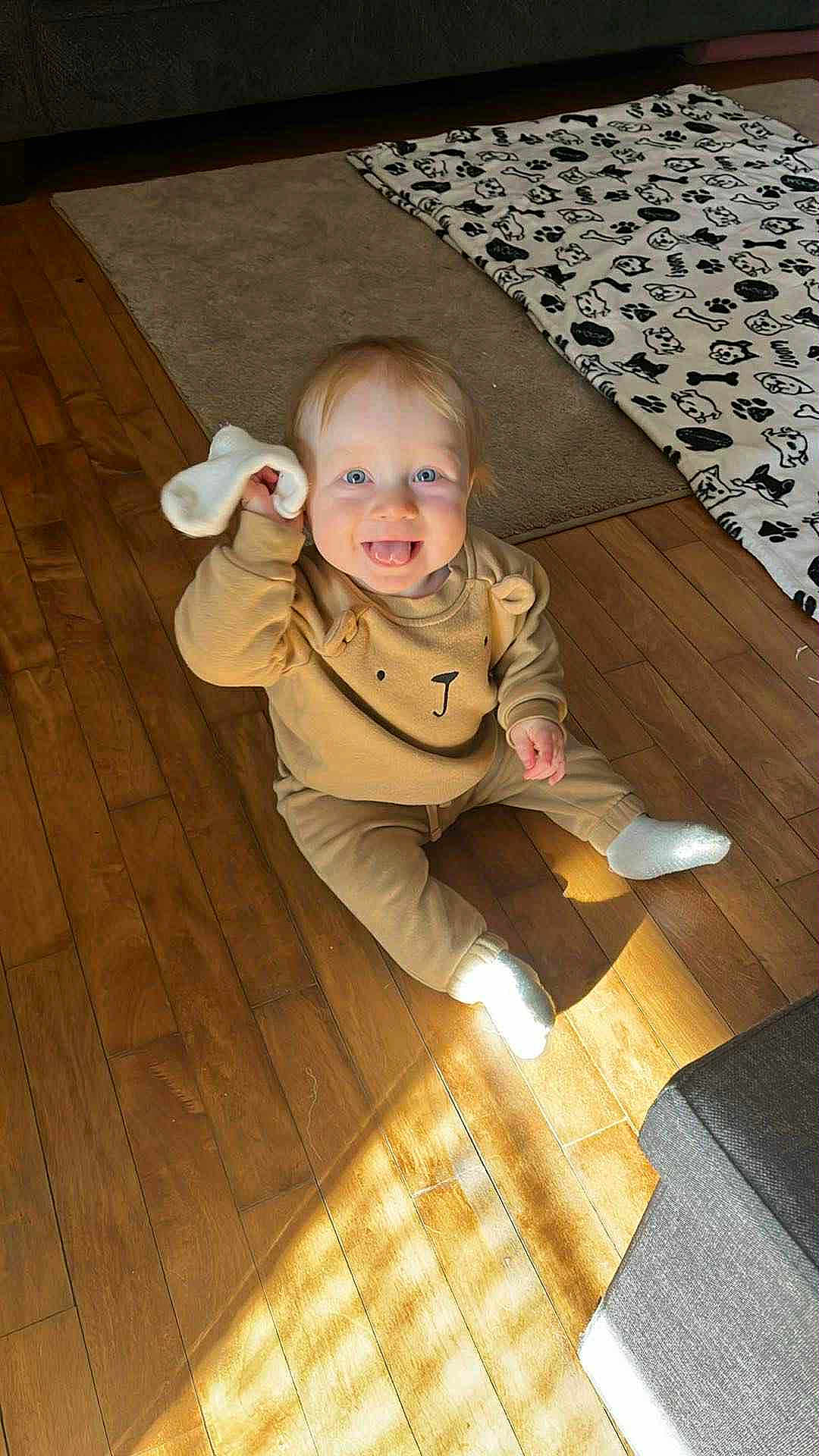 Oliver joined the competition — help win amazing prizes! baby, child, toddler, sock, wooden_floor, sunlight, smiling, happy, indoor, plush_clothing, bear_design, blue_eyes, cute, playful, floor_rug, blanket, cozy, couch, home, portrait