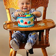 Oliver is registered to the contest to win money with this photo: baby, balloon, birthday, cake, cake_smash, child, crumbs, dessert, frosting, hands, happy, high_chair, indoor, mess, onesie, portrait, smile, socks, toddler, wooden_chair