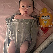 Elleigh is registered to the contest to win money with this photo: baby, infant, blanket, swaddle, face, tongue, toy, fox, pacifier, bed, pink, gray, sleeping_area, cute, child, newborn, lying_down, soft_lighting, indoor, person