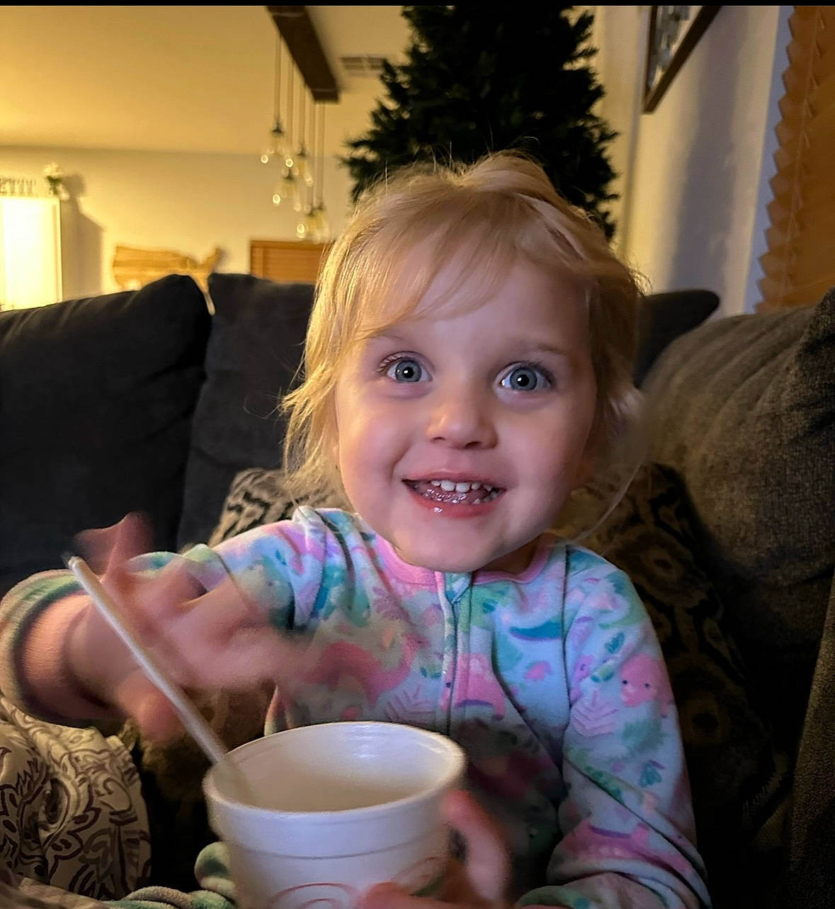 Payson is registered to the contest to win money with this photo: child, comfort, couch, cup, drink, drinkware, event, fun, happy, iris, joy, lamp, living_room, person, room, serveware, sitting, smile, spoon, tableware