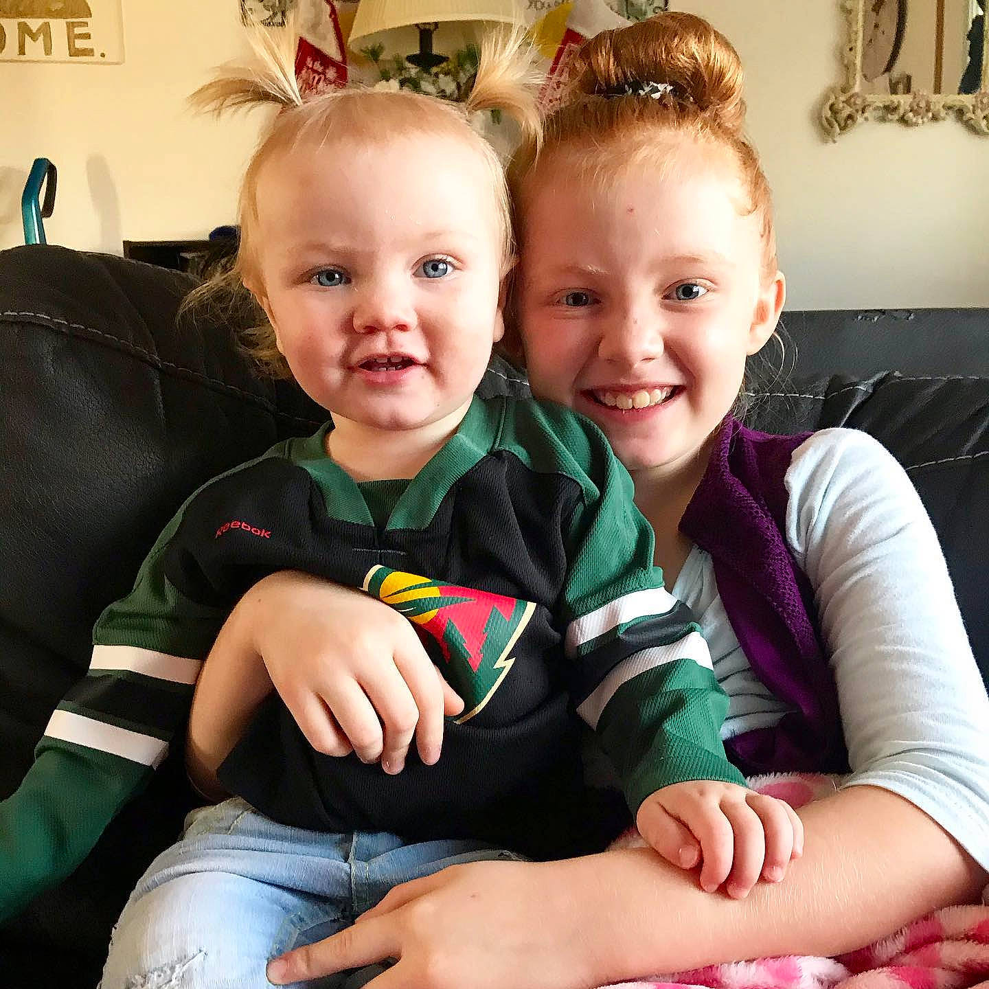 Emma is registered to the contest to win money with this photo: baby, baby_toddler_clothing, child, comfort, couch, eye, hair_accessory, hand, happy, iris, joy, lap, laugh, mouth, nail, person, picture_frame, playing_with_kids, sitting, smile