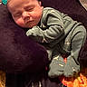 Zayne is registered to the contest to win money with this photo: baby, sleeping, pajamas, green_clothing, cushion, purple, blanket, indoor, infant, cozy, soft, child, peaceful, resting, cute, young, portrait, head, face, sleep