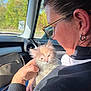 bag, black_sweater, car_interior, casual, cat, closeup, earring, fluffy, glasses, hand, holding, kitten, nature, pet, portrait, road, seat, sunlight, window, woman