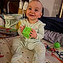 baby, child, smiling, toy, play_mat, pajamas, indoor, happy, infant, green, block, crawling, floor, cute, childhood, home, face, person, sitting, playtime