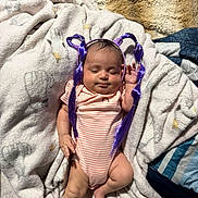 Scarlett joined the competition — help win amazing prizes! baby, infant, sleeping, face, portrait, indoors, blanket, bed, clothing, onesie, headband, purple_hair, costume, funny, cute, relaxed, lying_down, home, textile, photography