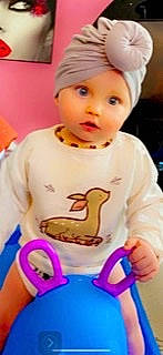 Nina a rejoint le concours — aidez-le/la à gagner de superbes lots ! baby, baby_toddler_clothing, cap, cheek, child, electric_blue, finger, fun, headwear, icing, person, pink, play, sitting, sleeve, thumb, toddler