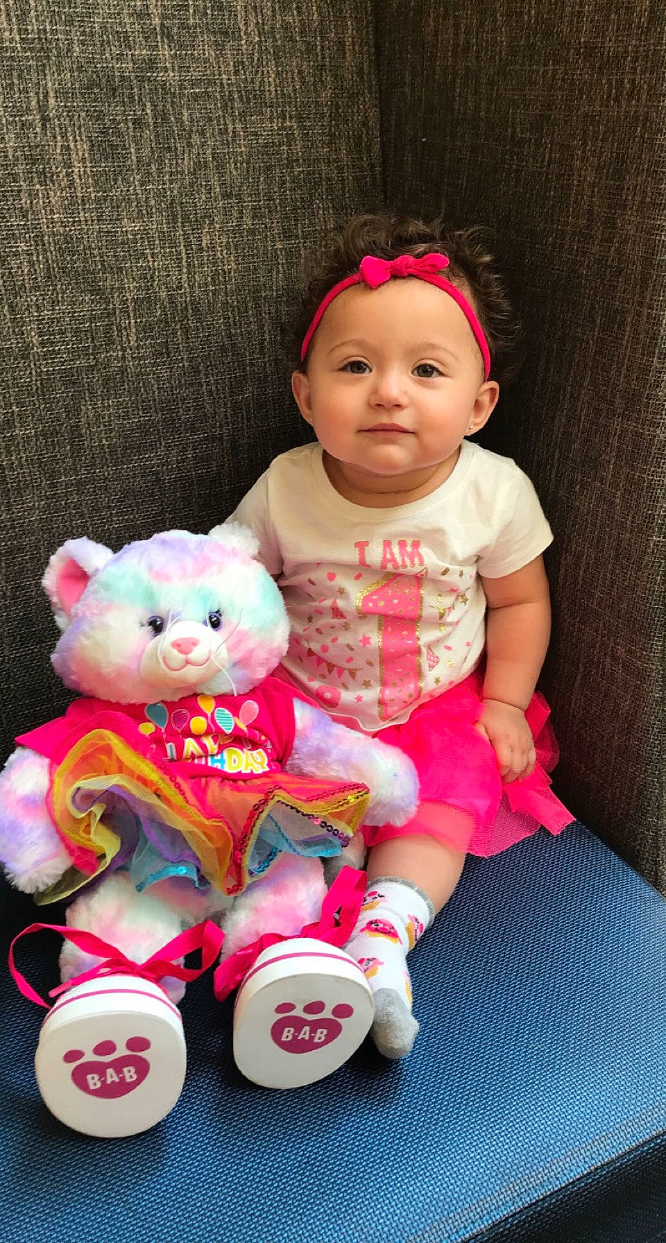 Ava Nichole is registered to the contest to win money with this photo: baby, baby_products, baby_toddler_clothing, cheek, child, dress, happy, headwear, magenta, pattern, person, pink, product, red, skin, sleeve, smile, teddy_bear, textile, toddler