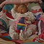 newborn, baby, sleeping, pajamas, baby_seat, blanket, pacifier, colorful, patterned, indoors, infant, child, cute, resting, soft_toys, fabric, comfort, safety_belt, home, peaceful