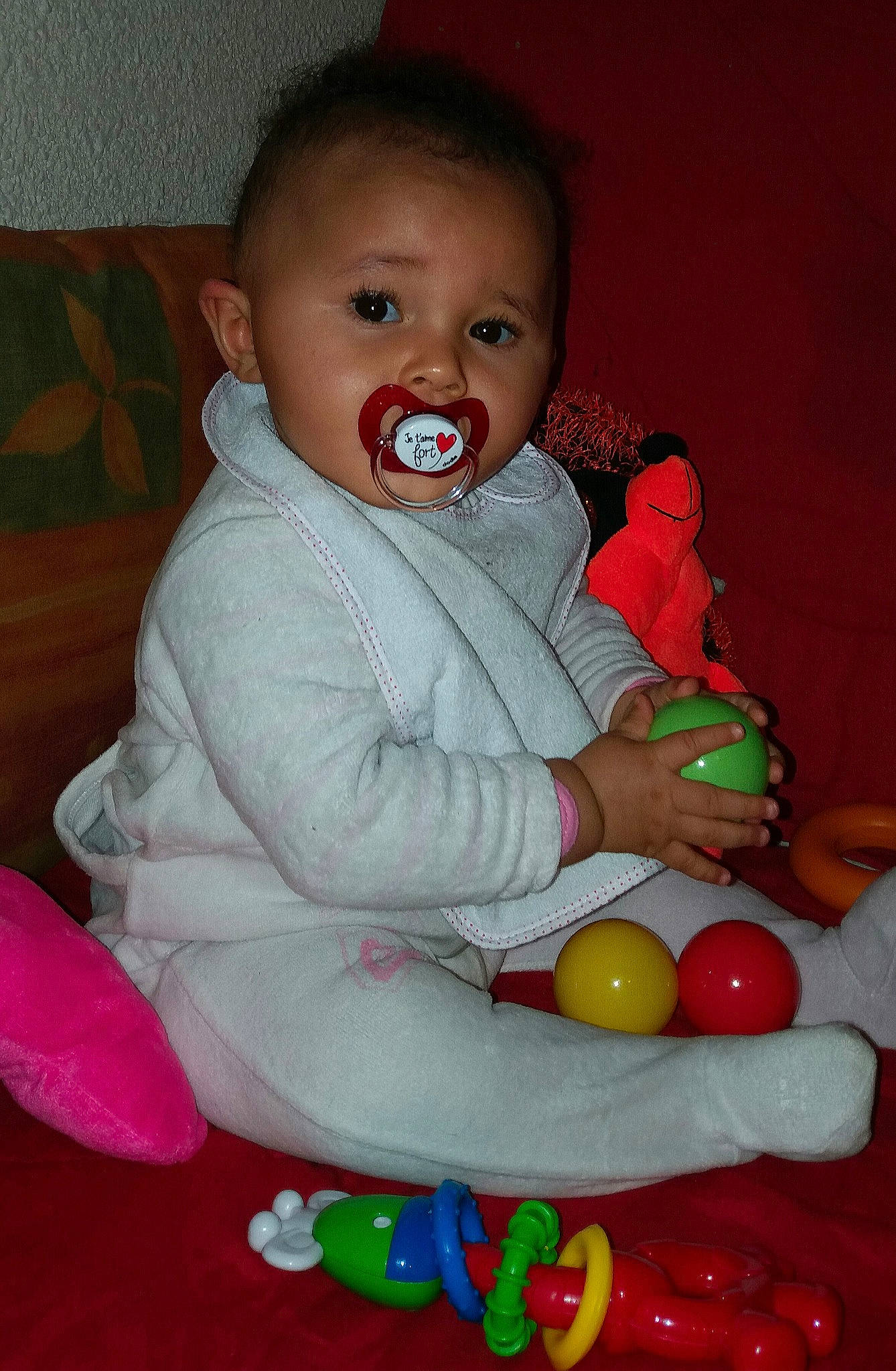 Dayana'A a rejoint le concours — aidez-le/la à gagner de superbes lots ! baby_products, baby_toys, cheek, child, eye, facial_expression, fun, girl, infant, iris, joy, laughter, person, pink, play, product, red, sitting, skin, smile