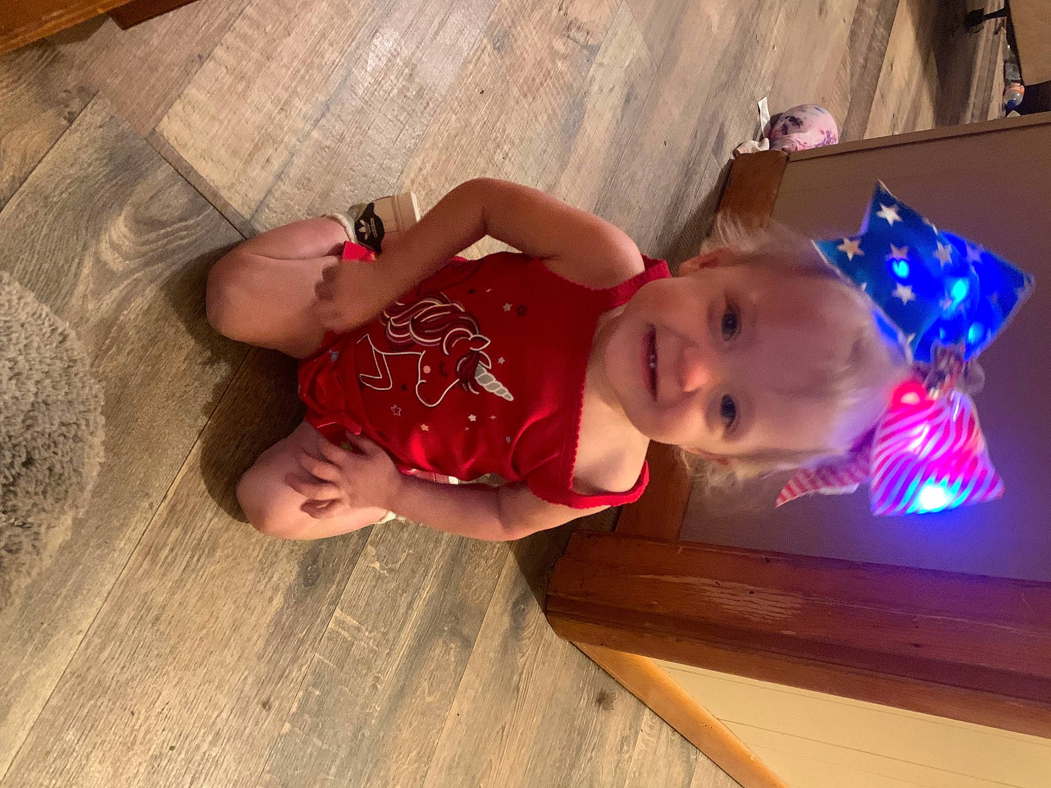Aaron is registered to the contest to win money with this photo: baby, baby_toddler_clothing, child, comfort, event, flooring, fun, hardwood, hat, joy, person, room, sitting, toddler, vacation, wood, wood_flooring