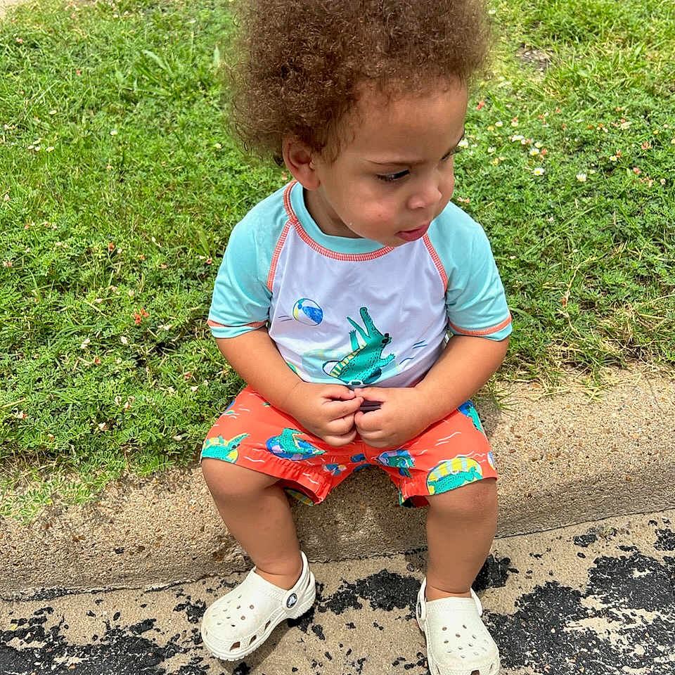 Eli joined the competition — help win amazing prizes! ball, child, clothing, face, female, football, footwear, girl, grass, head, person, photography, plant, portrait, shoe, shorts, sitting, soccer, soccerball, sport