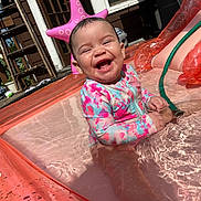 Adalaya is registered to the contest to win money with this photo: baby, child, infant, pool, water, swimsuit, inflatable_pool, smile, happy, outdoor, sunlight, starfish_float, hose, splash, play, summer, fun, joy, cute, sitting