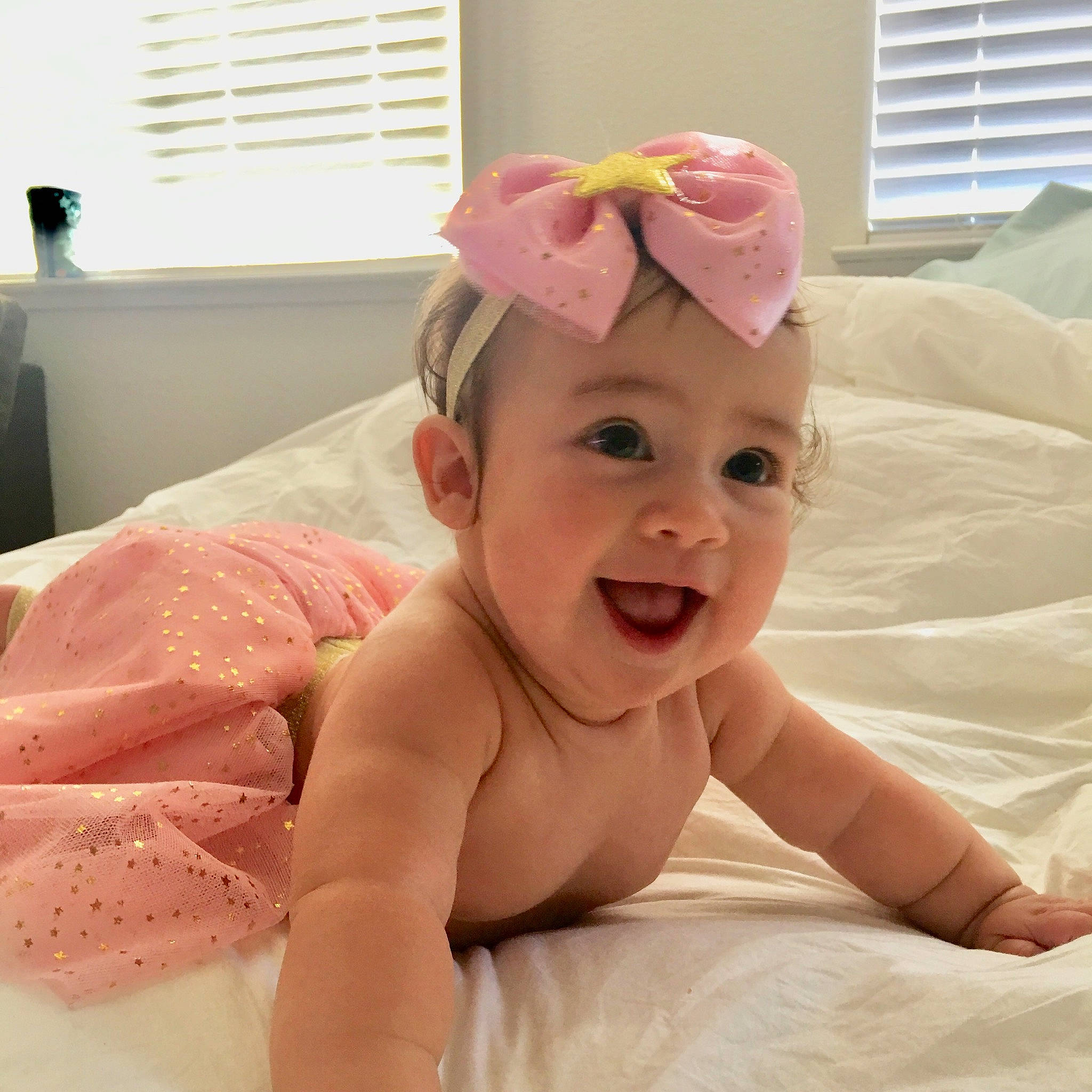 Eliana joined the competition — help win amazing prizes! baby, baby_products, baby_toddler_clothing, cheek, child, ear, face, fashion_accessory, hair_accessory, head, headgear, linens, neck, person, pink, product, room, skin, smile, textile