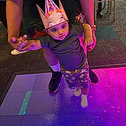 Major joined the competition — help win amazing prizes! child, baby, party_hat, led_floor, colorful_lights, indoor, adult_hands, holding_hands, camouflage_shorts, socks, sneakers, carpet, party, celebration, portrait, curious_expression, floor_tiles, neon_lighting, cute, person