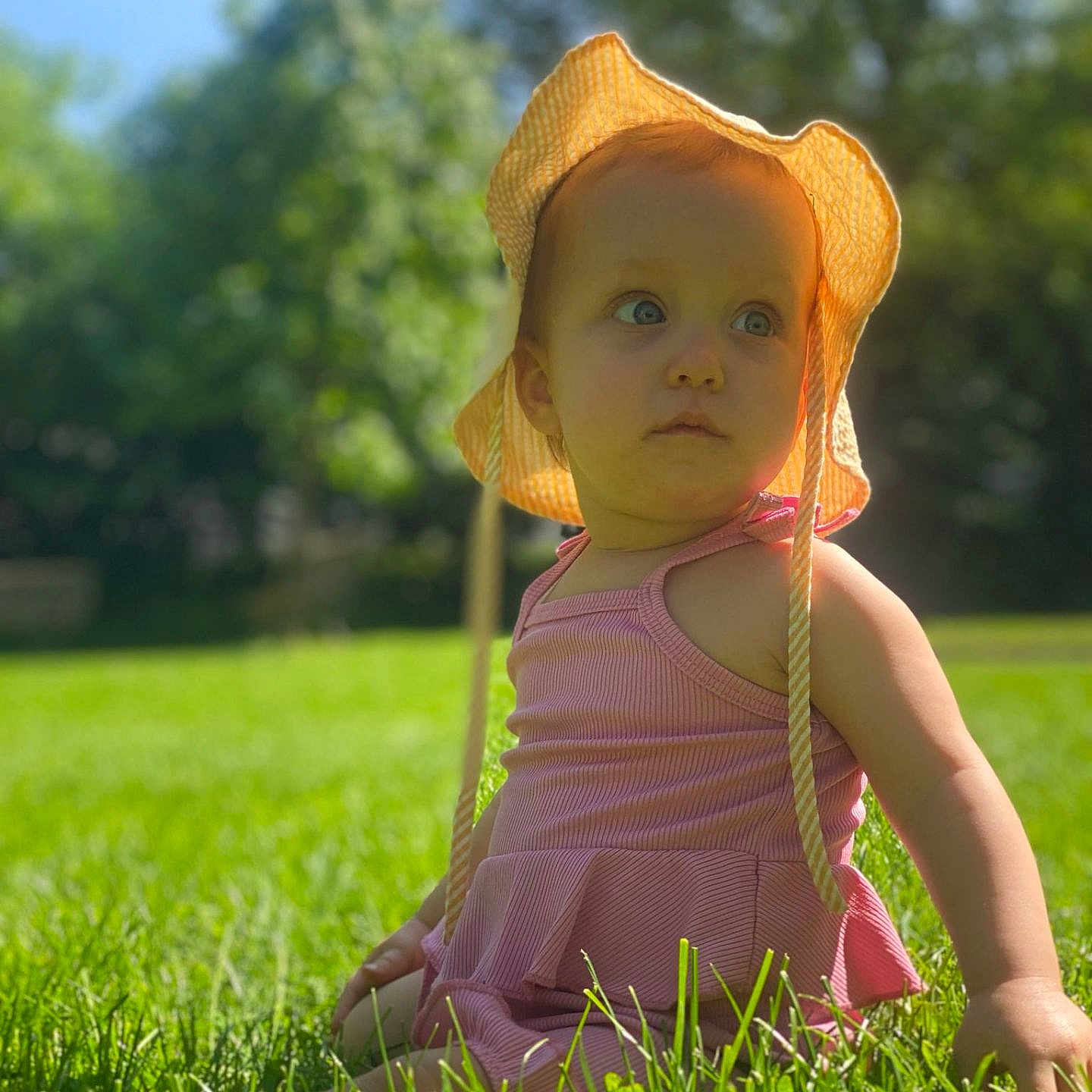 Léa participe au concours pour gagner de l'argent avec cette photo : baby, clothing, dress, face, grass, hat, head, lawn, nature, outdoors, park, person, photography, plant, portrait, sitting, summer, sunhat, tree, vegetation