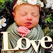 Kiara is registered to the contest to win money with this photo: newborn, baby, sleeping, flower_crown, green_wrap, wooden_sign, love, flowers, nature, peaceful, hands, portrait, infant, cute, soft_light, closeup, baby_face, resting, peace, decor