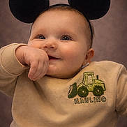 Jaxson joined the competition — help win amazing prizes! baby, infant, child, mouse_ears, headband, smile, chubby_cheeks, sweater, embroidery, tractor, portrait, close_up, cozy, hand_in_mouth, indoor, warm_lighting, cute, bright_eyes, soft_skin, casual_clothing