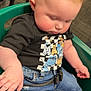 Jaxson is registered to the contest to win money with this photo: baby, toddler, infant, child, green_seat, jeans, tshirt, graphic_tee, buckle, belt, rosy_cheeks, blond_hair, spiky_hair, hand, arm, looking_down, sitting, indoor, carpet_floor, closeup