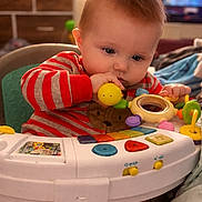 Jaxson joined the competition — help win amazing prizes! baby, child, toy, striped_pajamas, indoor, colorful, keyboard_toy, infantino, chewing, play, face, hands, seat, home, couch, blanket, furniture, cute, young, focused