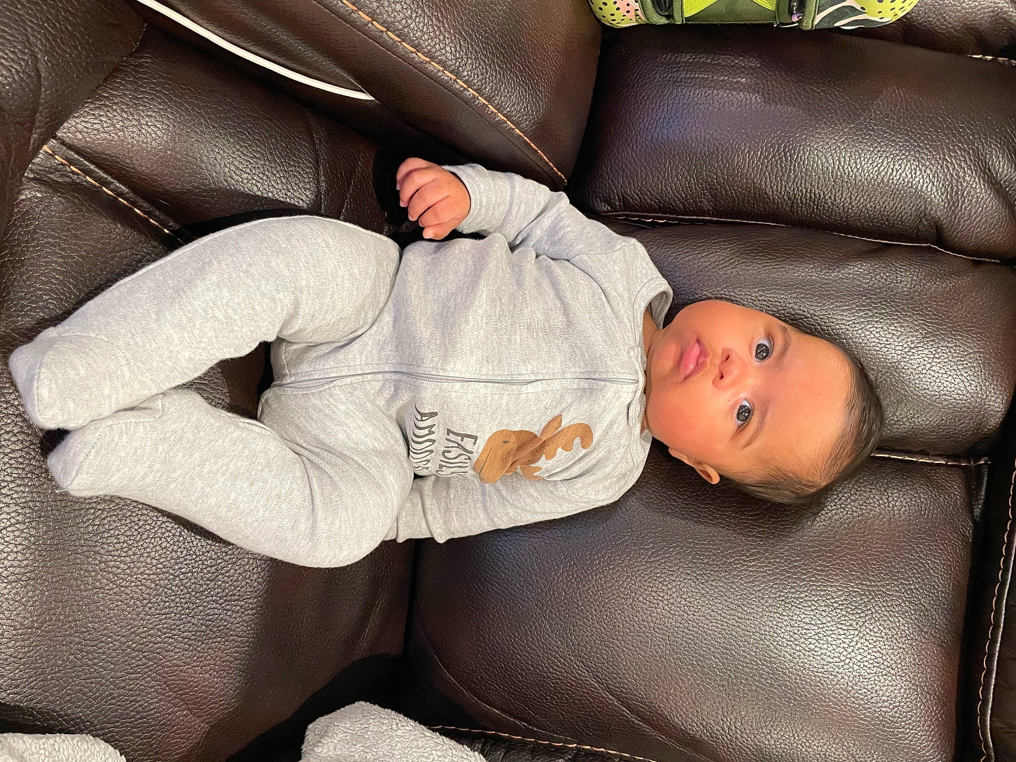 Saint is registered to the contest to win money with this photo: baby, baby_products, baby_toddler_clothing, car_seat, child, comfort, couch, elbow, head, human, human_body, human_leg, knee, lap, mammal, nap, person, sitting, suit, thigh