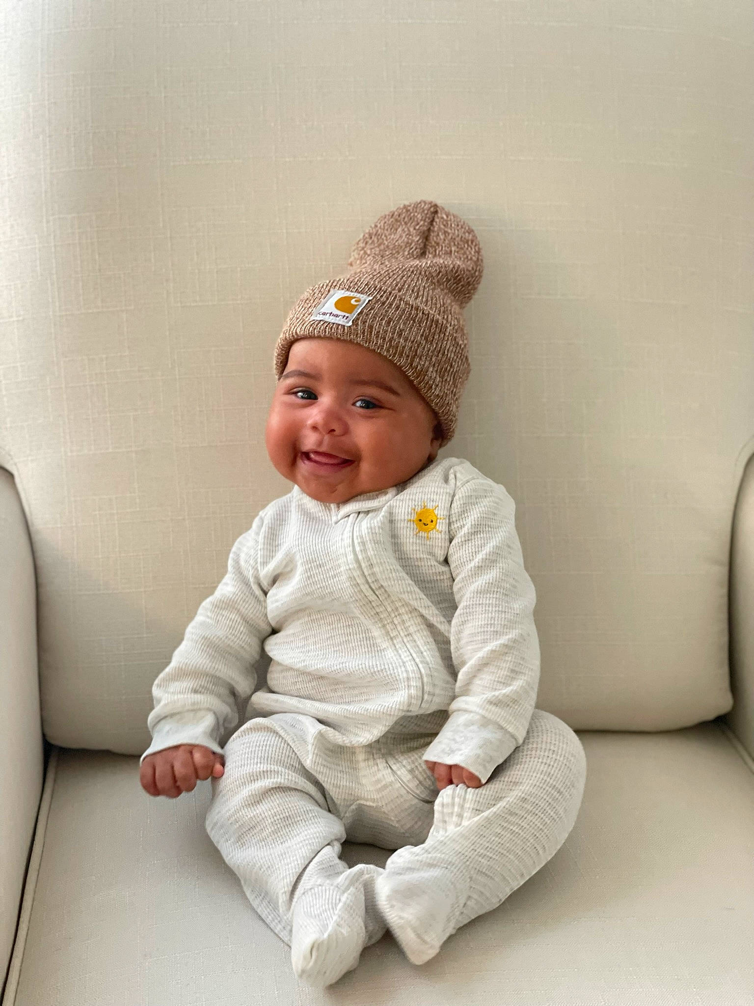 Saint is registered to the contest to win money with this photo: baby, baby_toddler_clothing, beanie, cap, child, collar, comfort, costume_hat, face, fashion_accessory, head, headwear, joy, knit_cap, outerwear, person, product, sitting, skin, sleeve