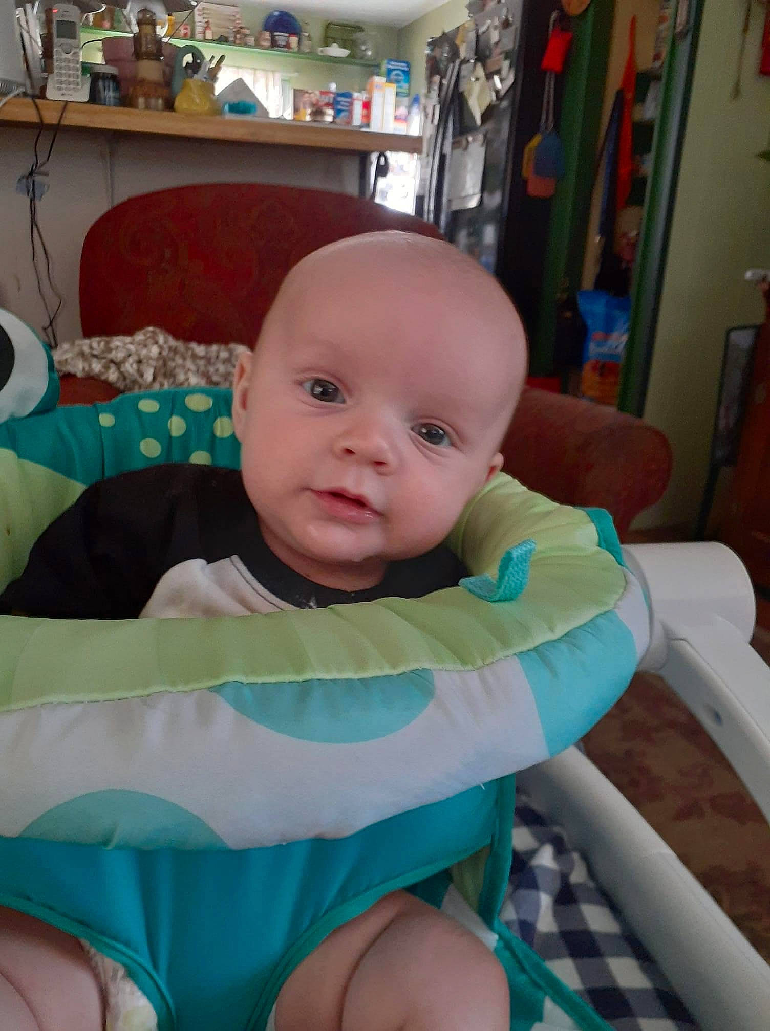 Bailey is registered to the contest to win money with this photo: baby, baby_products, baby_safety, baby_toddler_clothing, blue, bookcase, chair, cheek, child, comfort, eye, furniture, head, iris, linens, person, picture_frame, shelf, sitting, skin