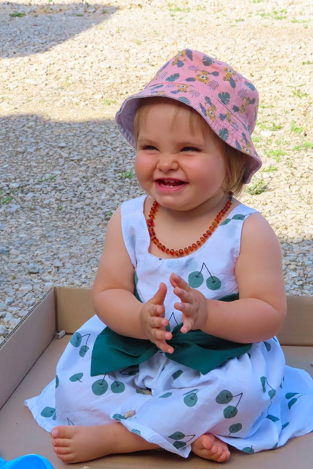Nono a rejoint le concours — aidez-le/la à gagner de superbes lots ! baby_toddler_clothing, blue, cap, dress, face, fun, grass, happy, hat, headwear, human_body, joy, leisure, person, photograph, pink, recreation, skin, smile, summer