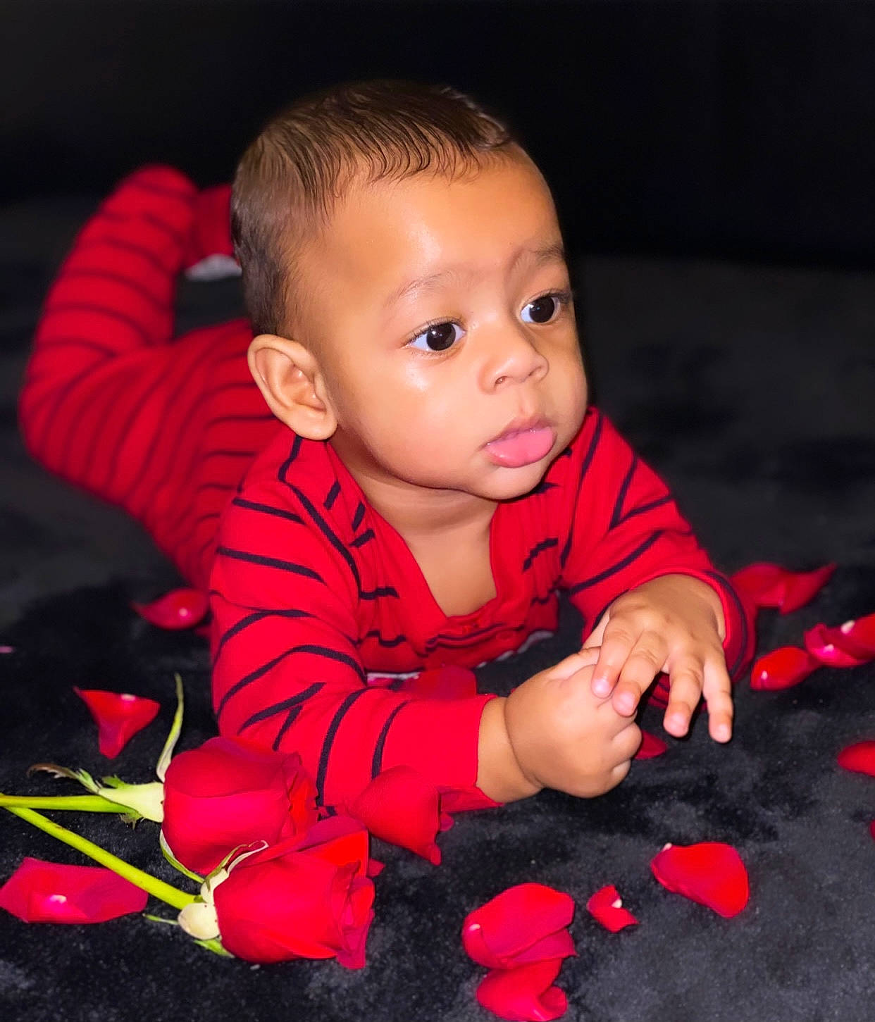 Dailan is registered to the contest to win money with this photo: arm, baby, baby_toddler_clothing, cheek, facial_expression, finger, flash_photography, flooring, fun, happy, iris, lip, nose, person, petal, plant, red, skin, sleeve, standing