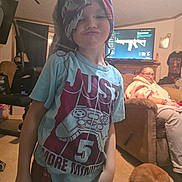 Harley is registered to the contest to win money with this photo: child, towel, turban, tshirt, pouting, living_room, woman, robe, couch, dog, sleeping_dog, television, video_game, game_controller_graphic, carpet, furniture, indoor, person, casual, relaxed