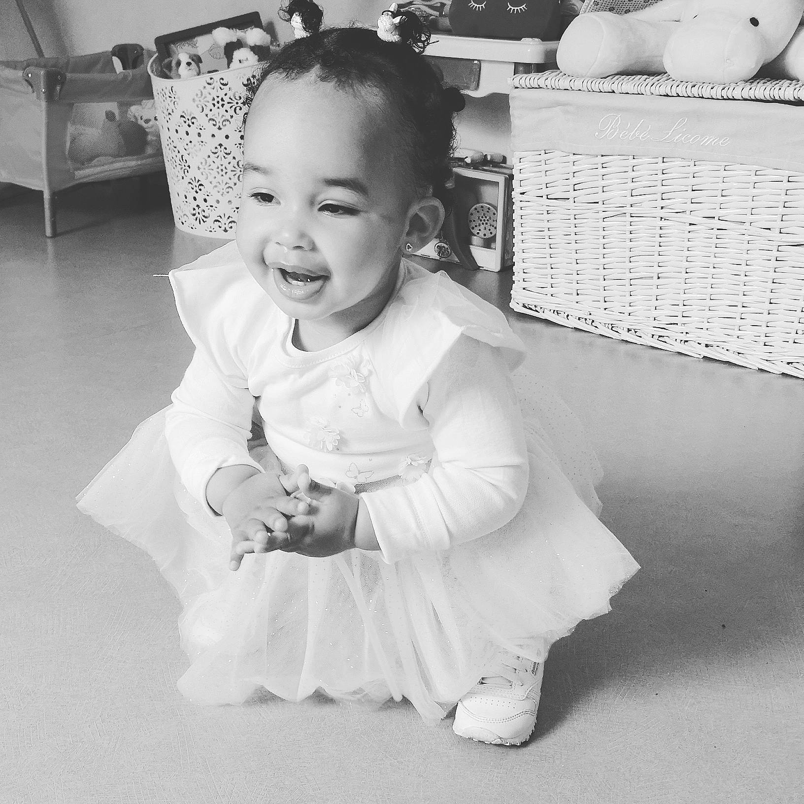 Sïa participe au concours pour gagner de l'argent avec cette photo : baby, black_and_white, child, dress, eye, face, facial_expression, hairstyle, head, iris, joy, monochrome, monochrome_photography, people, person, photograph, skin, smile, snapshot, standing