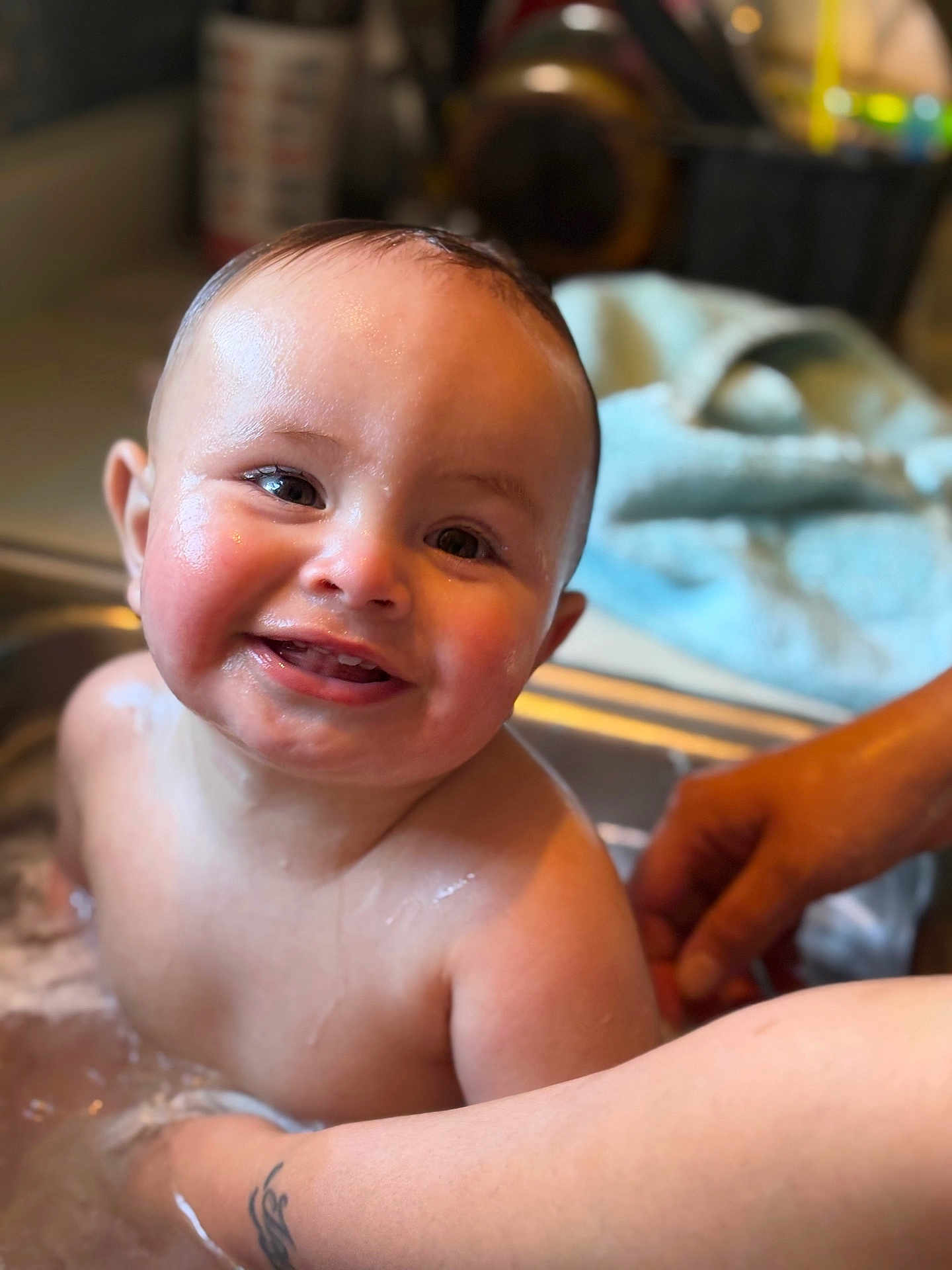 Luciano is registered to the contest to win money with this photo: baby, bath, sink, smile, water, wet_skin, child, person, tattoo, arm, kitchen, happy, cute, face, infant, skin, closeup, indoor, parent, family