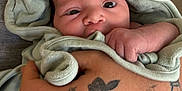 Vida joined the competition — help win amazing prizes! baby, closeup, cozy, curious, cute, expression, face, hand, holding, hooded_towel, human, indoor, infant, newborn, person, skin, soft, tattoo, towel, wrapped