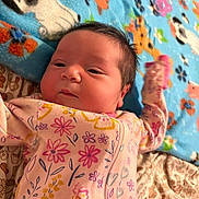 Vida is registered to the contest to win money with this photo: baby, newborn, infant, floral_pattern, onesie, blanket, animal_print, flower_print, sleepwear, child, cute, face, soft, lying_down, indoors, closeup, peaceful, skin, person, toddler
