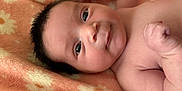 Vida is registered to the contest to win money with this photo: baby, infant, face, skin, eyes, arm, hand, blanket, soft, cute, newborn, child, portrait, lying_down, expression, flesh, closeup, cozy, warm, smiling