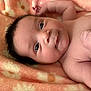 Vida is registered to the contest to win money with this photo: baby, infant, face, skin, eyes, arm, hand, blanket, soft, cute, newborn, child, portrait, lying_down, expression, flesh, closeup, cozy, warm, smiling