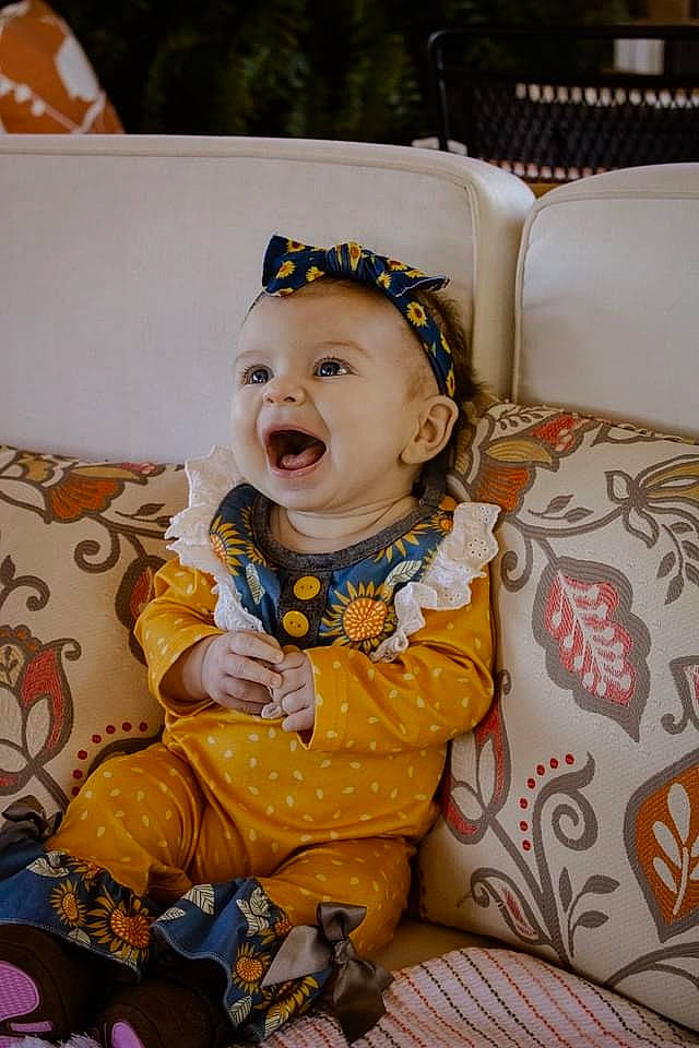 Magnolia is registered to the contest to win money with this photo: baby, baby_products, baby_toddler_clothing, chair, cheek, child, costume, event, fashion_accessory, fun, happy, human_body, pattern, person, room, sitting, skin, smile, toddler, tradition