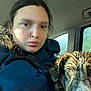 Bonnie is registered to the contest to win money with this photo: animal, brown_eyes, car_interior, closeup, dog, expressionless, face, fur, headrest, indoor, jacket, person, portrait, seat, seatbelt, sunlight, vehicle, wet_dog, wet_hair, window