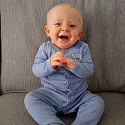 Andre joined the competition — help win amazing prizes! baby, child, smiling, blue_onesie, sitting, clapping_hands, happy, face, cute, infant, couch, furniture, indoors, cozy, young_child, portrait, expression, skin, head, eyes