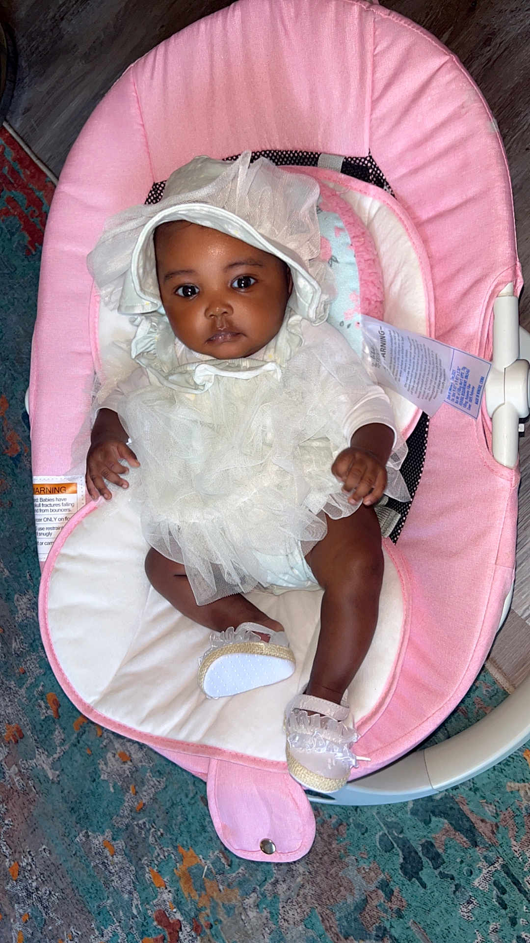 Jersi joined the competition — help win amazing prizes! baby, infant, child, pink_baby_seat, white_dress, bonnet, footwear, carpet, flooring, indoors, cute, portrait, person, soft_fabric, baby_shoes, seated, home, looking_at_camera, adorable, resting