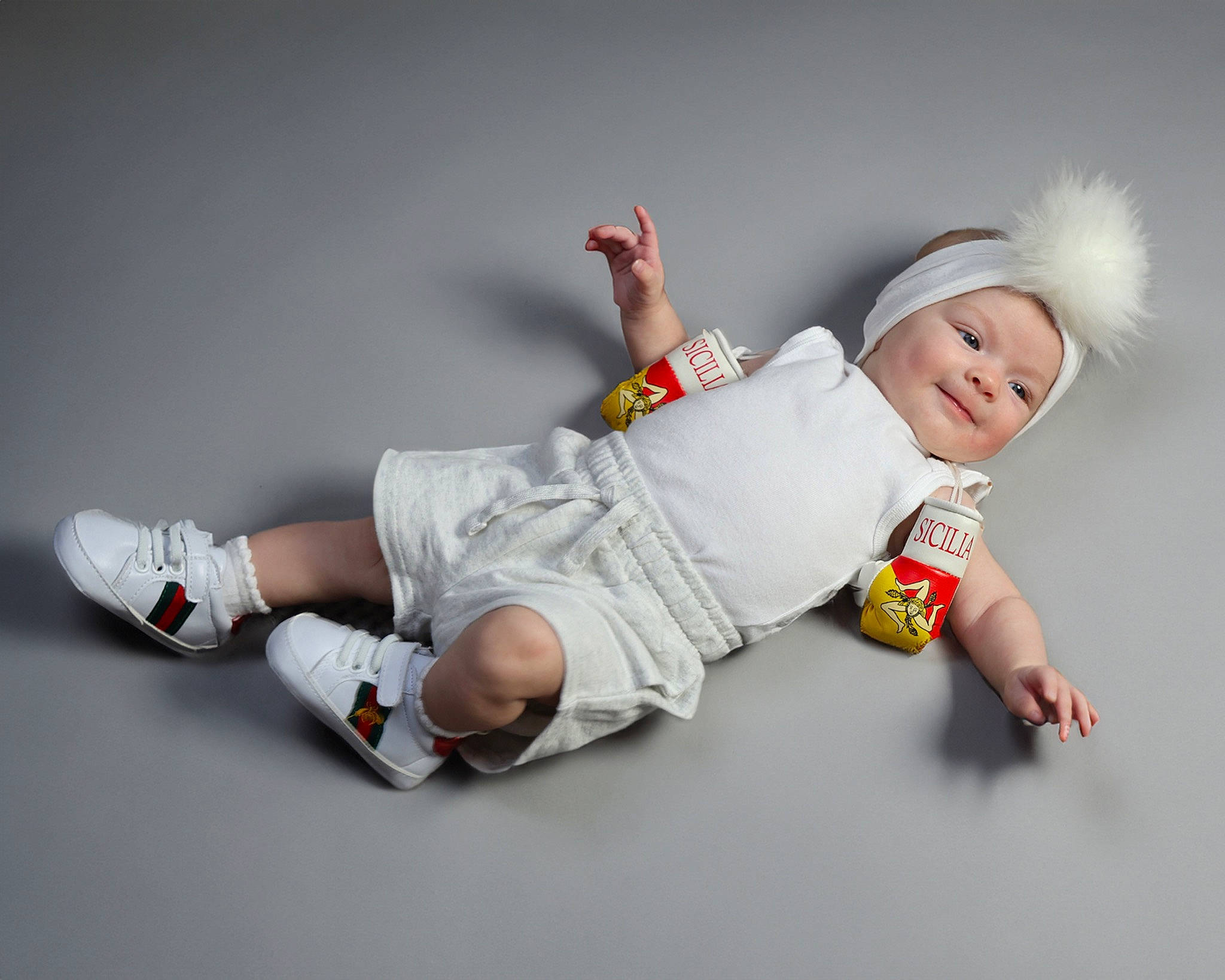 Viviana is registered to the contest to win money with this photo: baby, baby_toddler_clothing, barefoot, child, comfort, elbow, flooring, foot, happy, headwear, human_body, human_leg, knee, leg, person, sitting, sleeve, sock, t_shirt, thigh