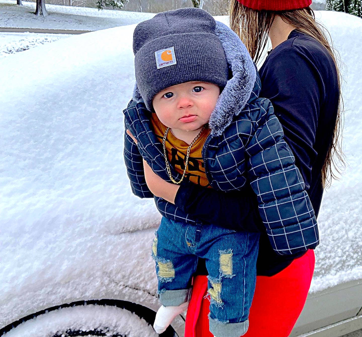 Tyton is registered to the contest to win money with this photo: automotive_tire, baby, beanie, cap, child, freezing, fun, headgear, headwear, jacket, knit_cap, leisure, pattern, person, recreation, sitting, snapshot, snow, street_fashion, toddler