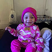 Diana is registered to the contest to win money with this photo: baby, beanie, blanket, child, couch, cozy, cute, face, happy, home, indoor, person, pink_clothing, playful, portrait, sitting, smiling, socks, toddler, warm
