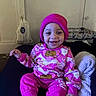 baby, beanie, blanket, child, couch, cozy, cute, face, happy, home, indoor, person, pink_clothing, playful, portrait, sitting, smiling, socks, toddler, warm