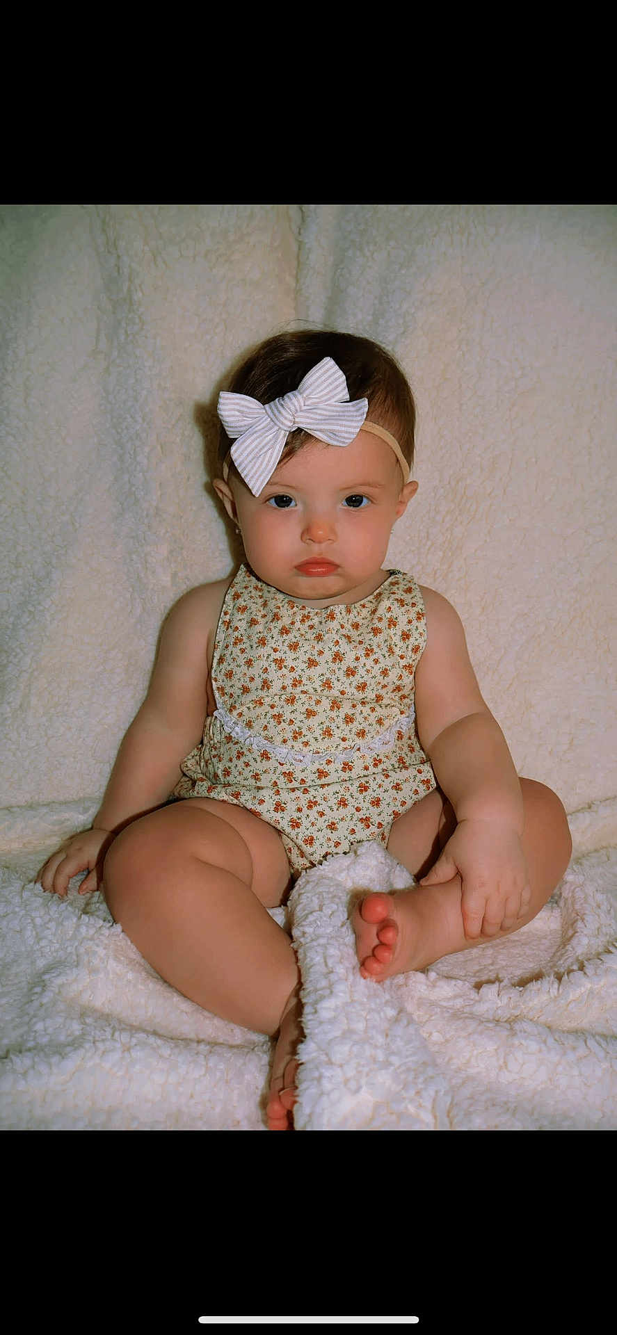 Harper joined the competition — help win amazing prizes! baby, child, infant, bow, headband, romper, floral_pattern, blanket, soft_texture, cute, sitting, foot, hand, indoors, portrait, skin, chubby_cheeks, expression, young, person